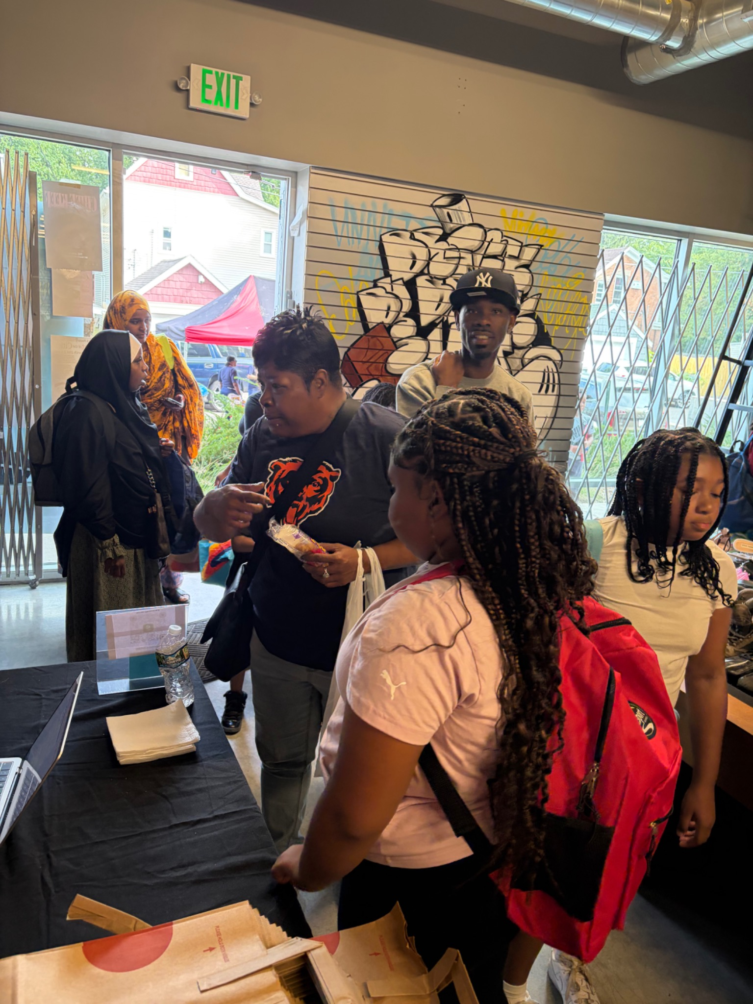 Child and caregiver browsing clothing and shoes at the Fresh and Fly Bash indoor venue