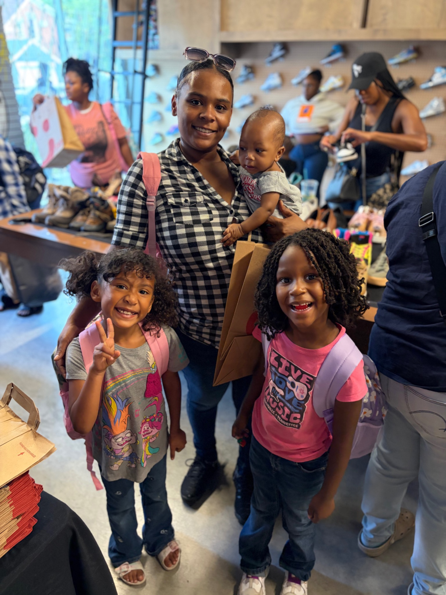 Mother and children smiling together with backpacks at the Fresh and Fly Back-to-School Bash