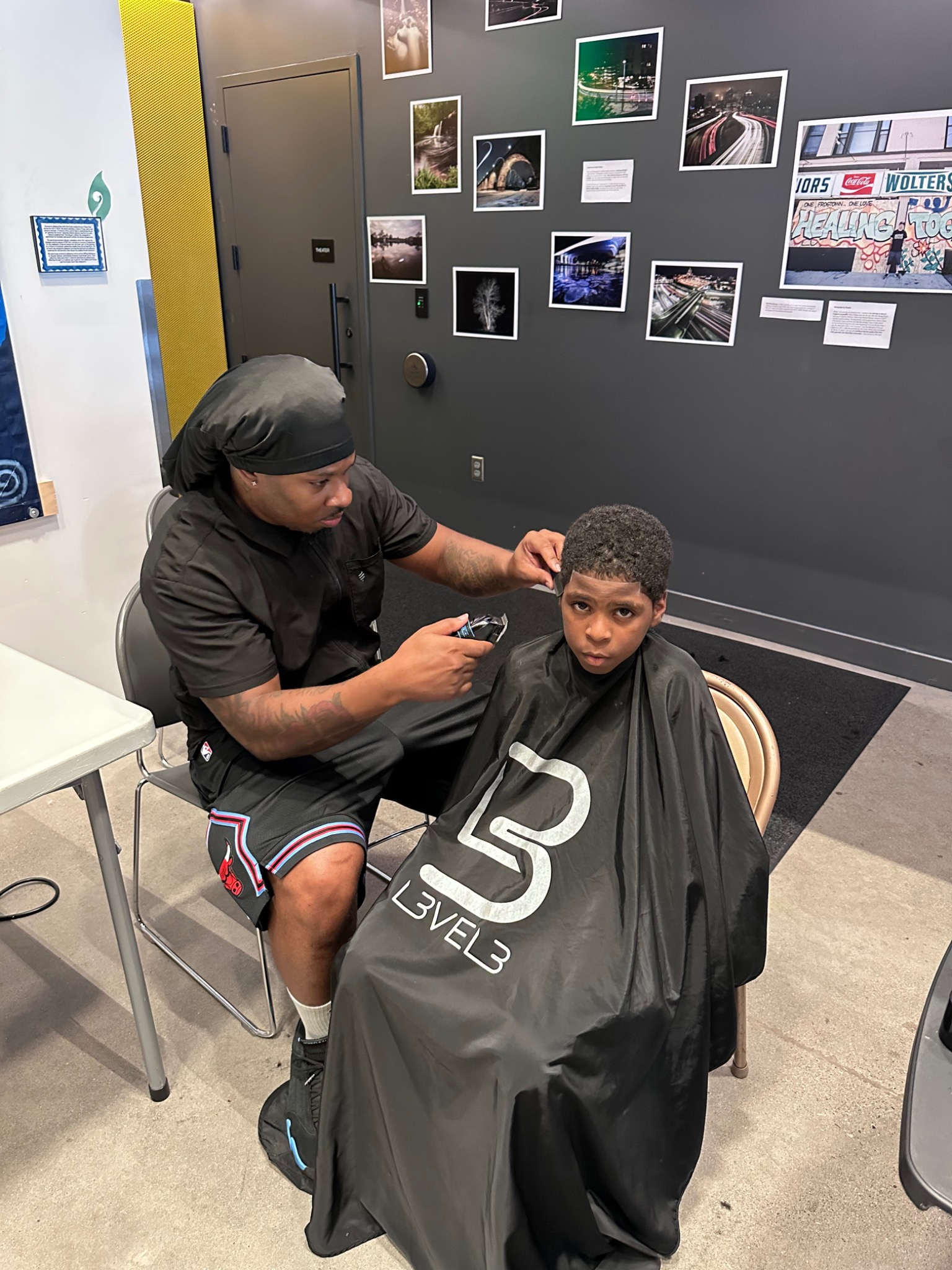 Barber cutting a child's hair at the Fresh and Fly Back-to-School Bash